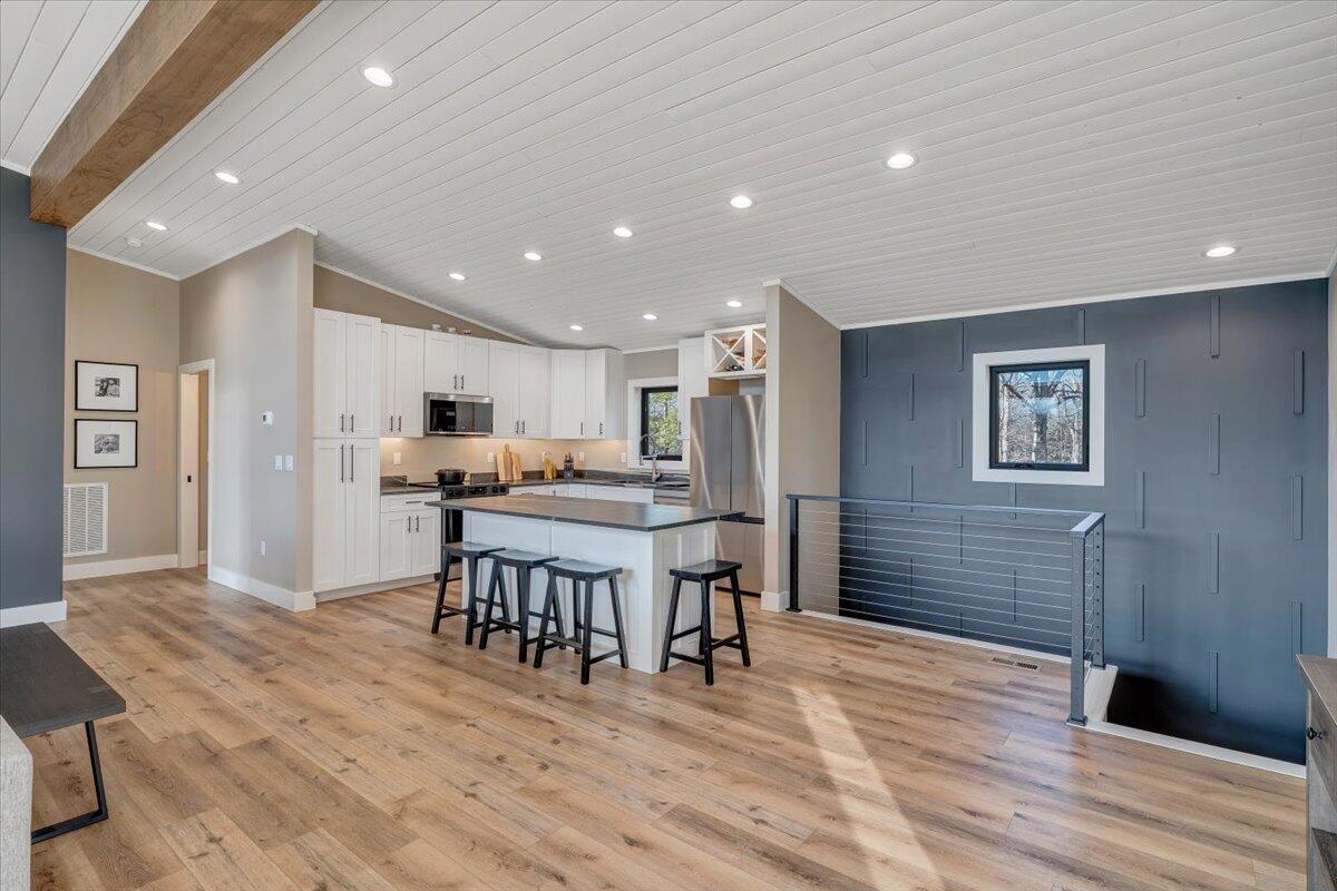 5 Reserve Road Moneta, VA 24121 - Photo 16 of 95 a kitchen with stainless steel appliances kitchen island granite countertop a refrigerator a stove a microwave oven a dining table and chairs with wooden floor