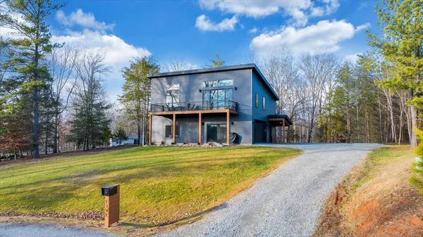 a kitchen with stainless steel appliances kitchen island granite countertop a refrigerator a stove a microwave oven a dining table and chairs with wooden floor