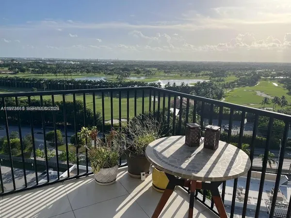 a view of a balcony with wooden chairs and a floor to ceiling window