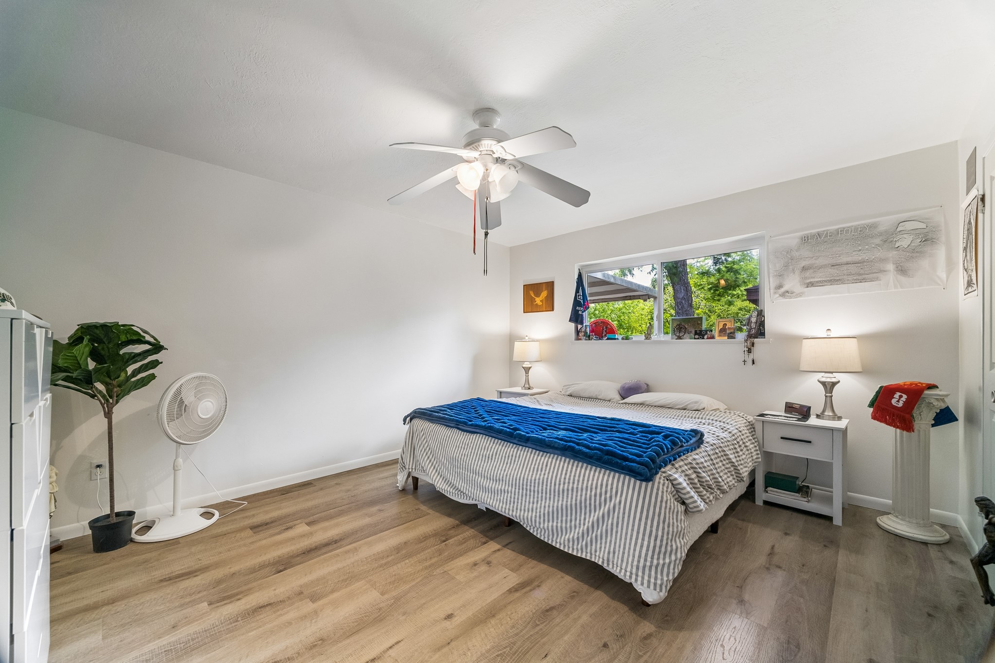 413 Mebane Lane Rosenberg, TX 77471 - Photo 4 of 30 This bedroom features a cozy design with light wood flooring, a ceiling fan, and ample natural light from a large window. This primary bedroom is the perfect owner's retreat.