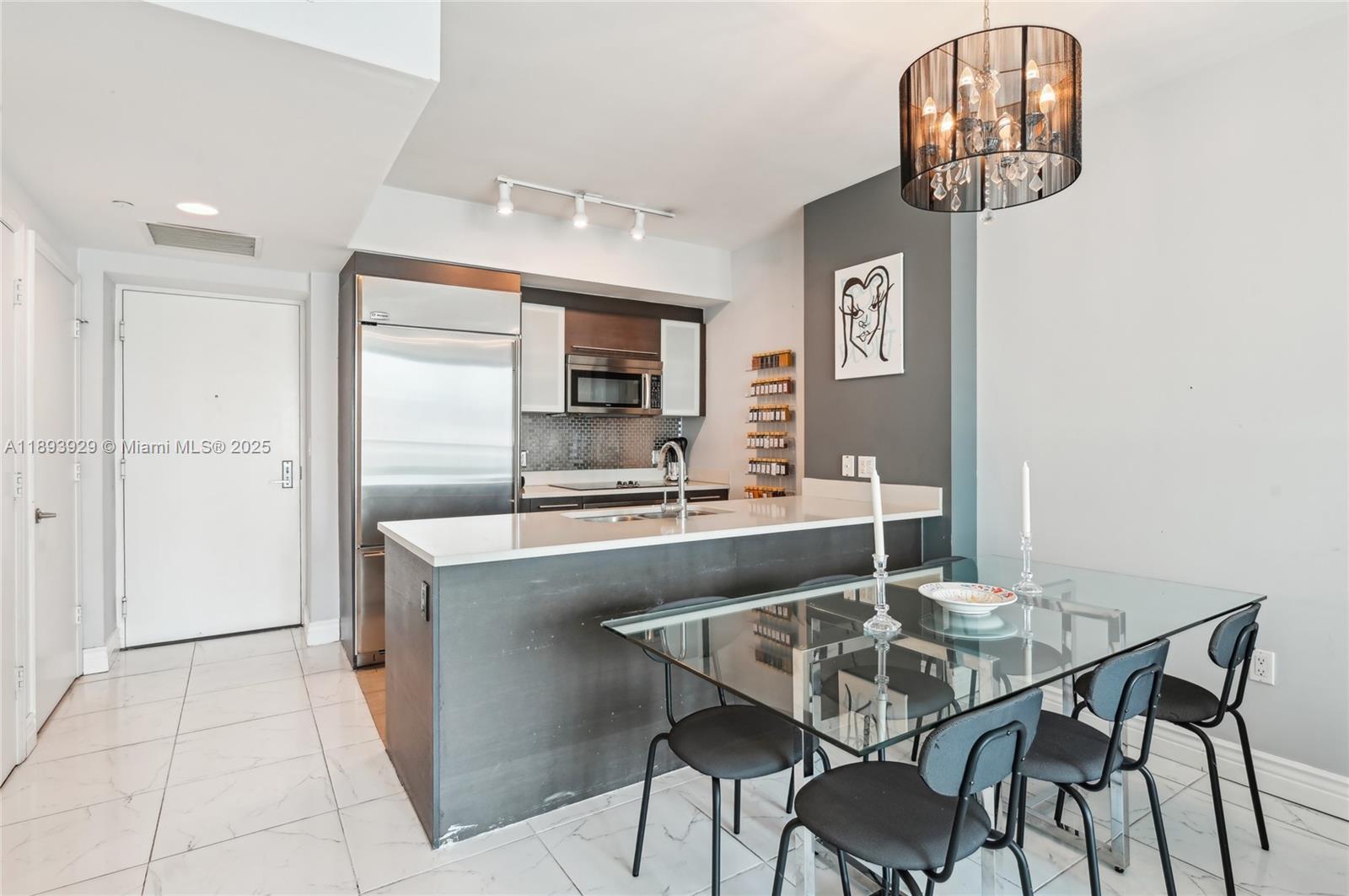 55 Southeast 6th Street, Unit 1608 Miami, FL 33131 - Photo 8 of 24 a kitchen with a table and chairs in it