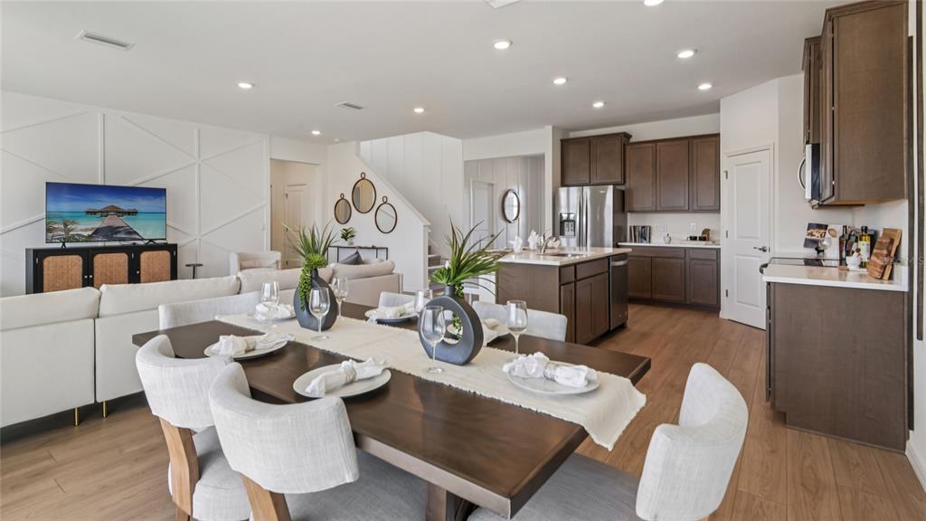 11238 Duckling Way Weeki Wachee, FL 34613 - Photo 11 of 30 a kitchen with kitchen island granite countertop a dining table chairs stainless steel appliances and wooden floor