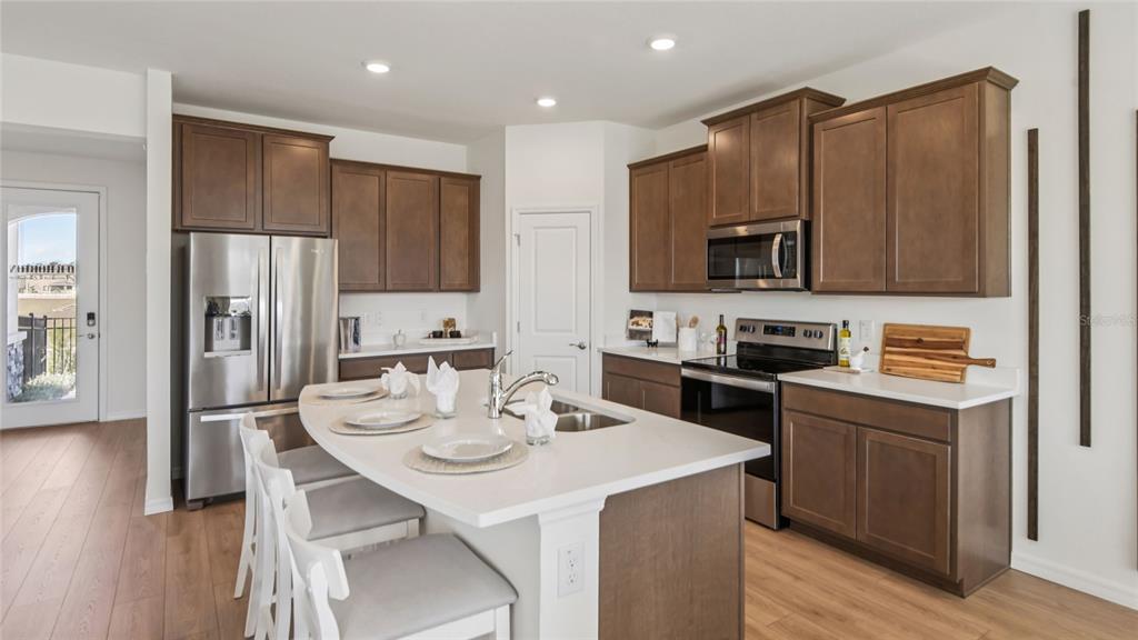 11238 Duckling Way Weeki Wachee, FL 34613 - Photo 5 of 30 a kitchen with a sink a stove a refrigerator and white cabinets