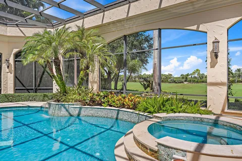 an aerial view of a golf course with huge green field and large trees