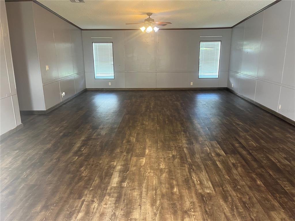 1145 Yaun Road Southeast Moore Haven, FL 33471 - Photo 6 of 26 an empty room with wooden floor and windows