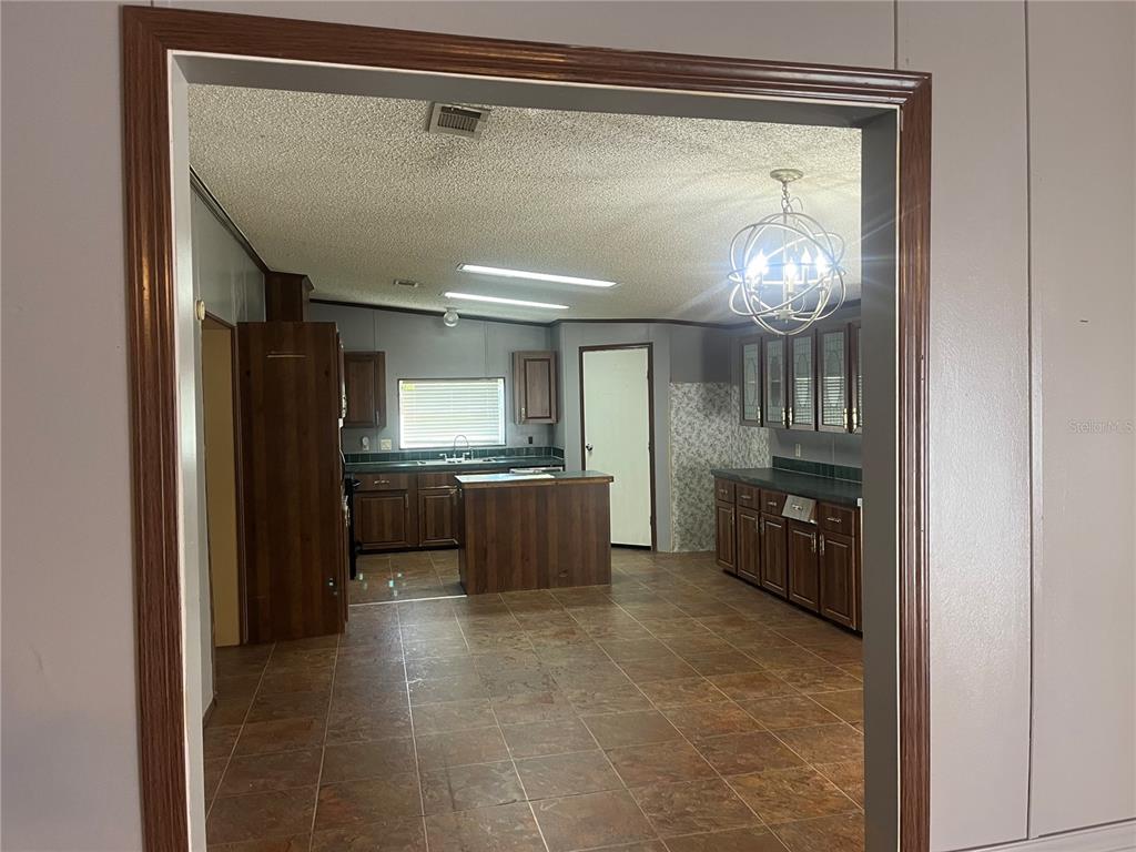 1145 Yaun Road Southeast Moore Haven, FL 33471 - Photo 7 of 26 a kitchen with stainless steel appliances a refrigerator and a wooden floor