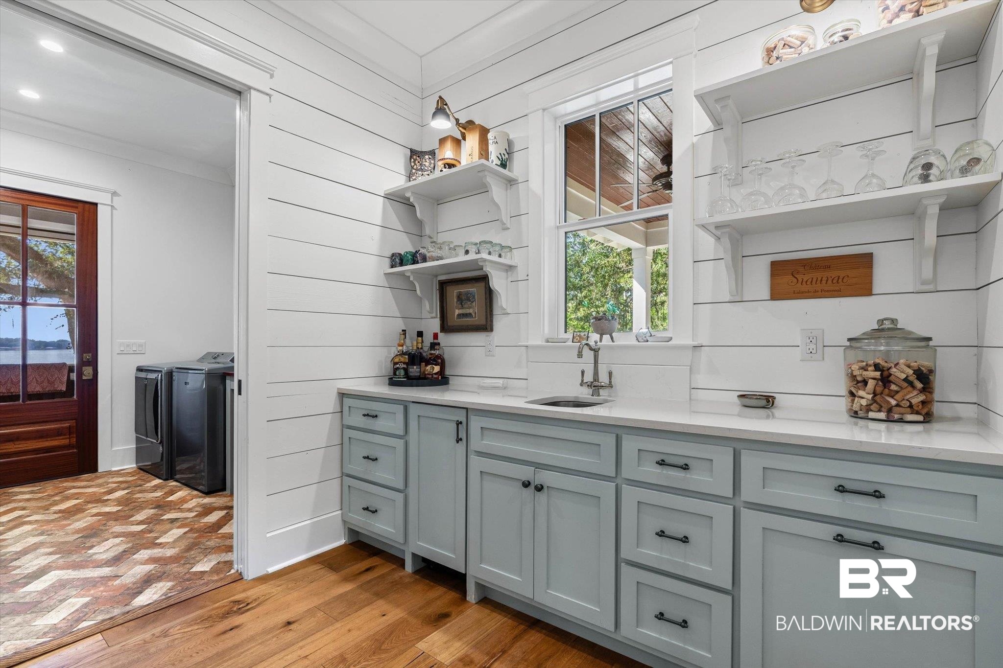2415 Venetia Road Mobile, AL 36605 - Photo 21 of 50 Indoor wet bar featuring open shelves, light stone counters, washer and dryer, light wood-style floors, and gray cabinetry