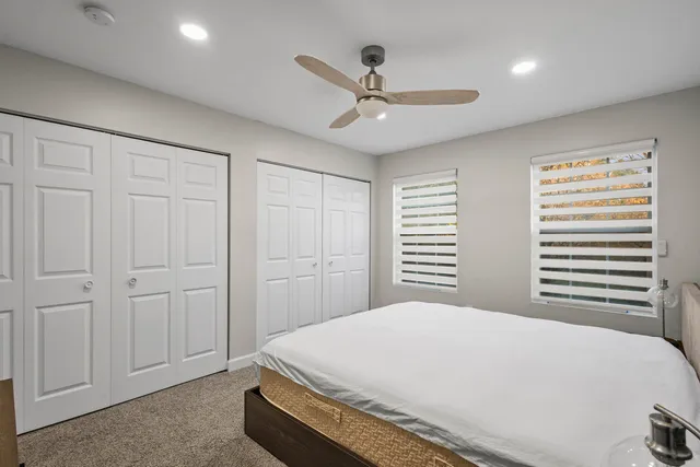 a bed room with a bed and a ceiling fan