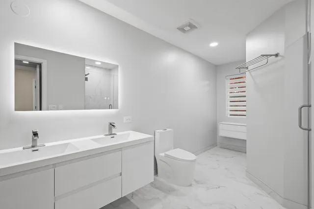 a bathroom with a toilet sink and mirror