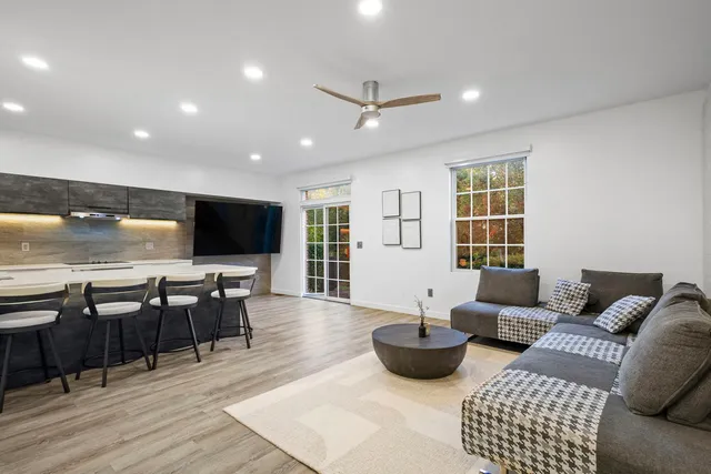 a living room with furniture kitchen view and a flat screen tv