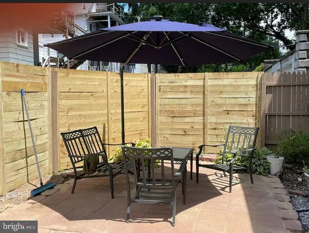 a view of balcony with chairs and table under an umbrella