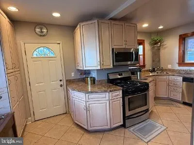 a kitchen with stainless steel appliances granite countertop a stove a sink and a microwave