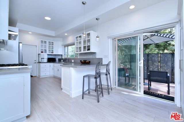 a open kitchen with white cabinets and stainless steel appliances