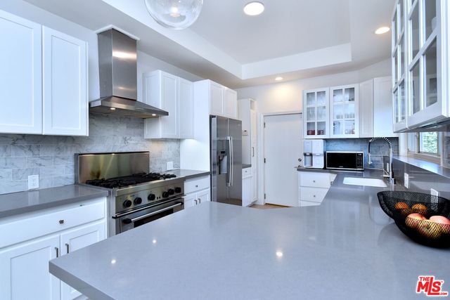a kitchen with stainless steel appliances a stove a refrigerator and a sink