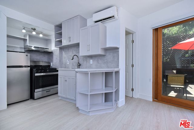 a kitchen with stainless steel appliances a stove a refrigerator and a sink