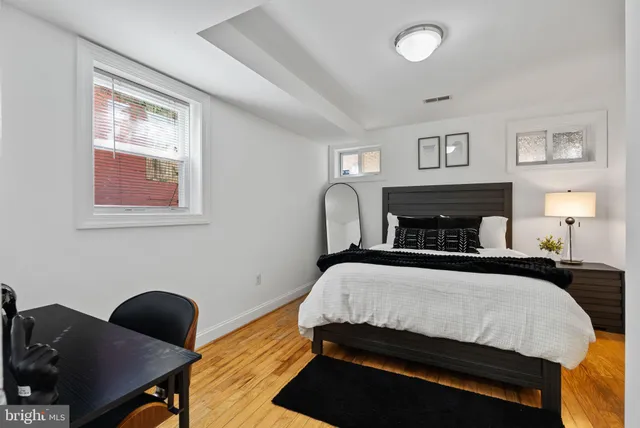 a bedroom with a bed and a lamp next to a window