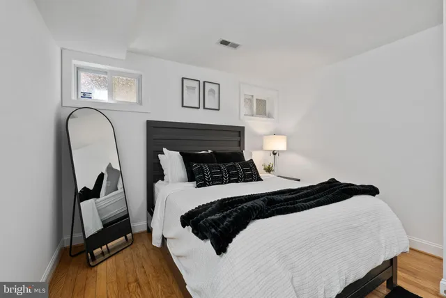 a bedroom with a bed a couch and a potted plant