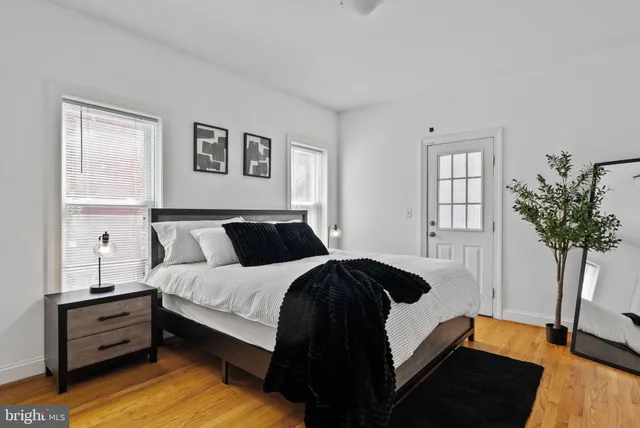a bedroom with bed window and potted plant