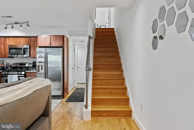 a view of a kitchen with wooden floor and electronic appliances