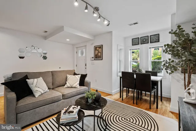 a living room with furniture and wooden floor