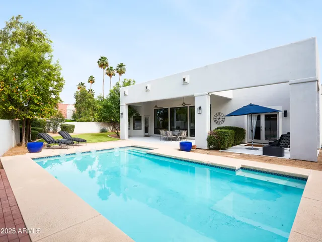 a view of a house with pool and sitting area