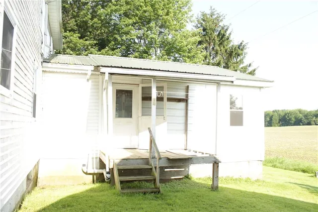 a view of a chair and table in backyard of the house