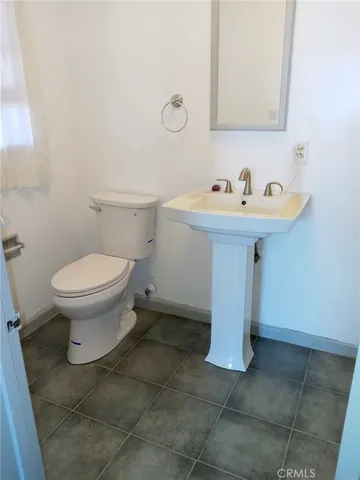 a bathroom with a sink toilet and a mirror