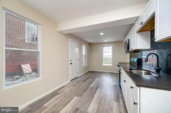 a kitchen with granite countertop a sink stove and cabinets