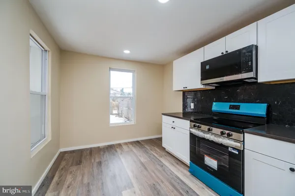 a kitchen with stainless steel appliances a stove microwave and sink