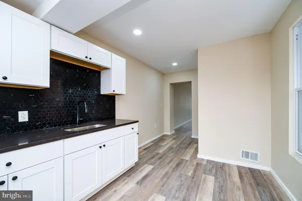 a kitchen with granite countertop white cabinets and black appliances