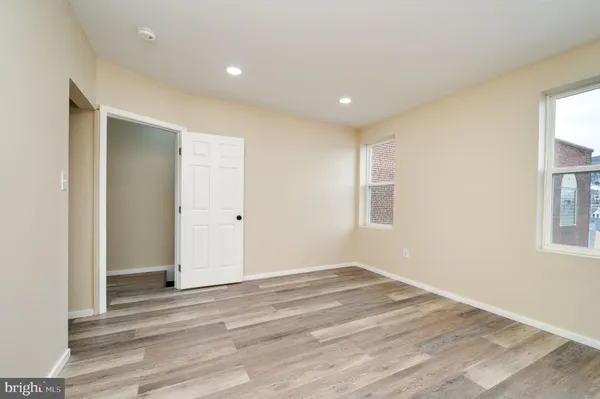 a view of a room with wooden floor and windows