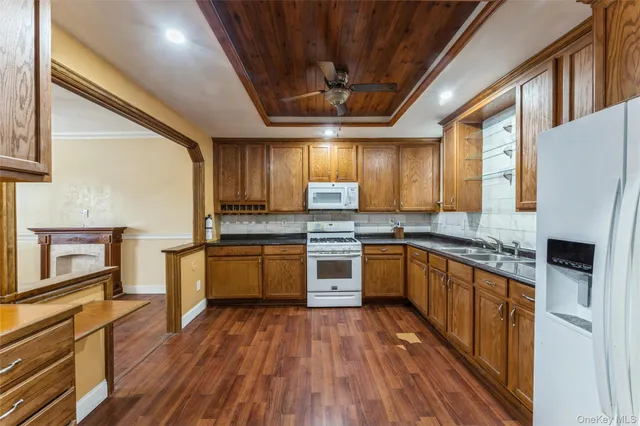 a kitchen with stainless steel appliances granite countertop wooden floors a stove and a refrigerator