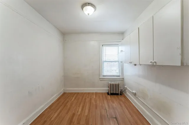 a view of a room with wooden floor and cabinets