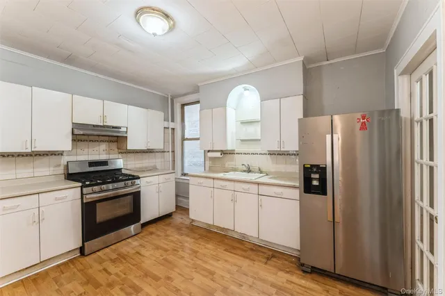 a kitchen with white cabinets and stainless steel appliances
