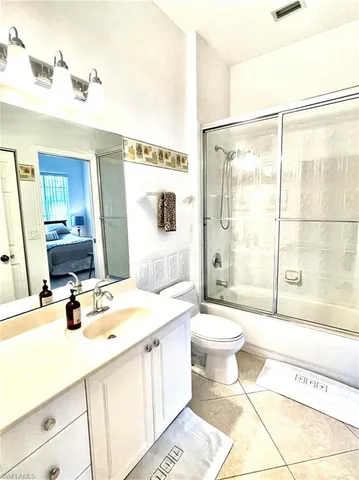 a spacious bedroom with a bed and a chandelier