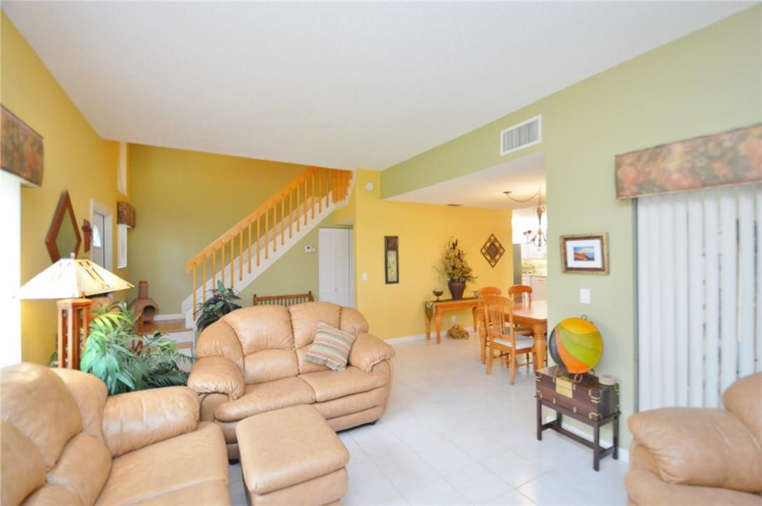 573 Racquet Club Road, Unit 15 Weston, FL 33326 - Photo 9 of 23 a living room with furniture and a chandelier