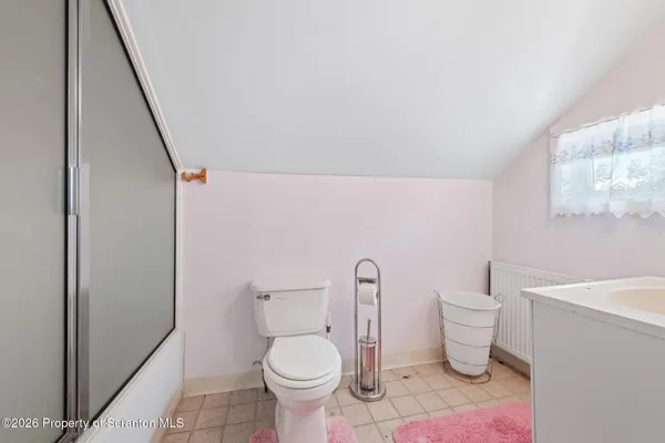a white toilet sitting next to a bathroom sink and vanity