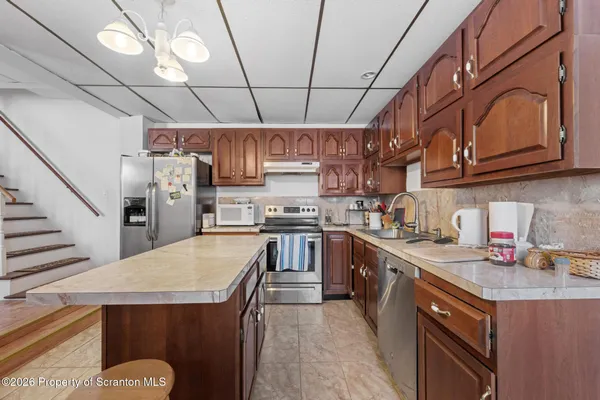 a kitchen with stainless steel appliances granite countertop a sink a stove and cabinets