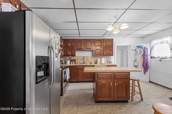 a kitchen with stainless steel appliances granite countertop a refrigerator and a stove top oven
