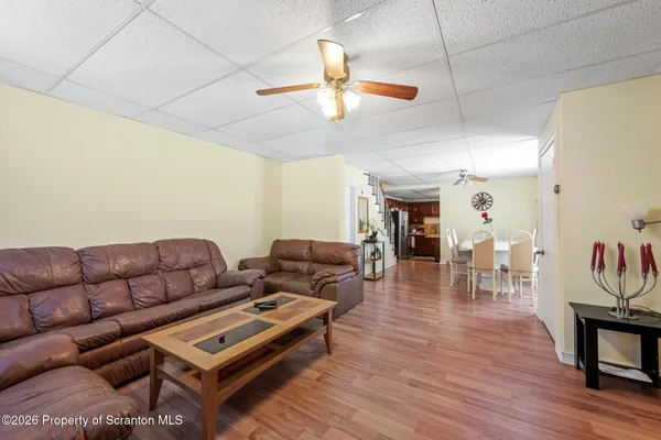a living room with furniture a ceiling fan and a rug