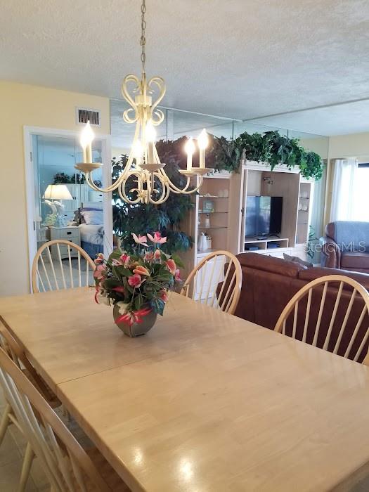 13650 Gulf Boulevard, Unit 304 Madeira Beach, FL 33708 - Photo 27 of 63 a view of a dining room with furniture and a chandelier