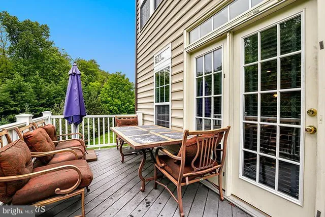 a balcony with wooden floor and outdoor seating