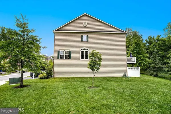 a front view of a house with a yard and trees