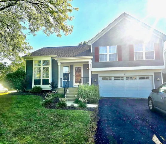 a front view of a house with a garden and plants