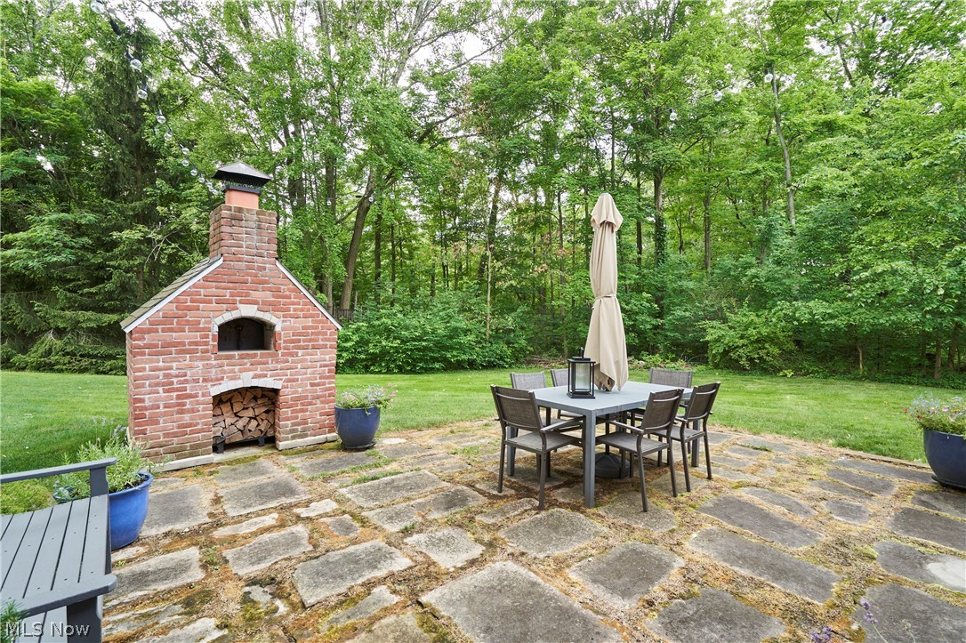 5046 Alger Road Richfield, OH 44286 - Photo 7 of 49 Expansive backyard featuring a stone paver patio, mature trees, and a built-in brick oven with chimney