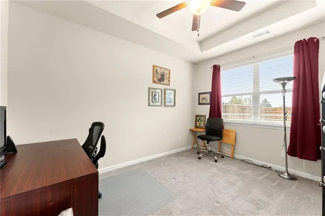 a view of a workspace with furniture and a window