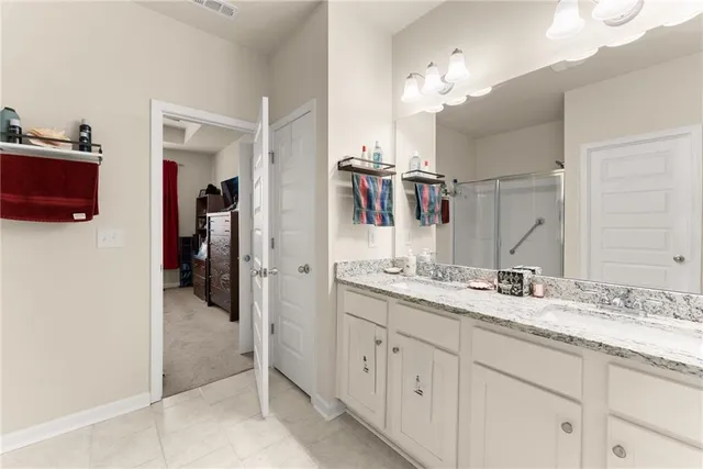 a bathroom with a double vanity sink a mirror and a shower