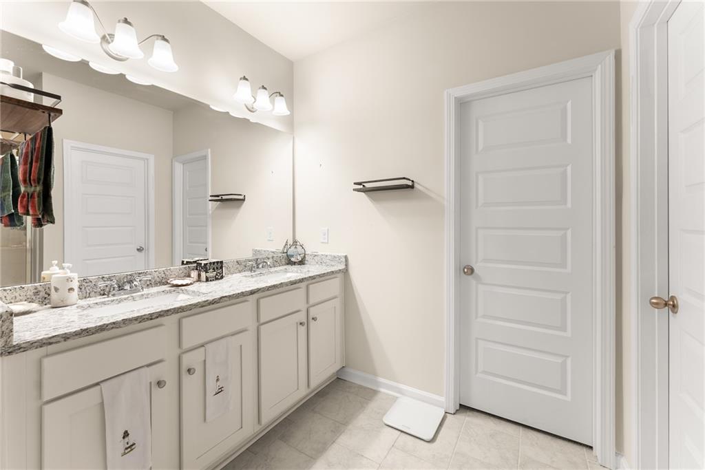 3914 Prospect Point Drive Oakwood, GA 30566 - Photo 20 of 30 a bathroom with a double vanity sink a mirror and a shower