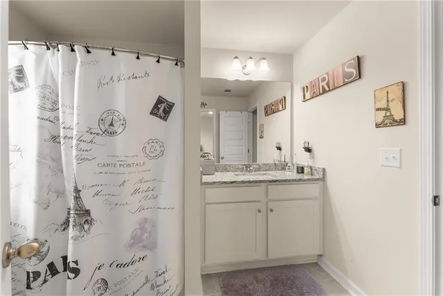 a bathroom with a granite countertop sink a mirror a vanity and a shower
