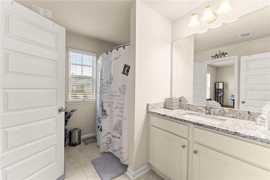 3914 Prospect Point Drive Oakwood, GA 30566 - Photo 24 of 30 a bathroom with a granite countertop sink a mirror a vanity and a shower